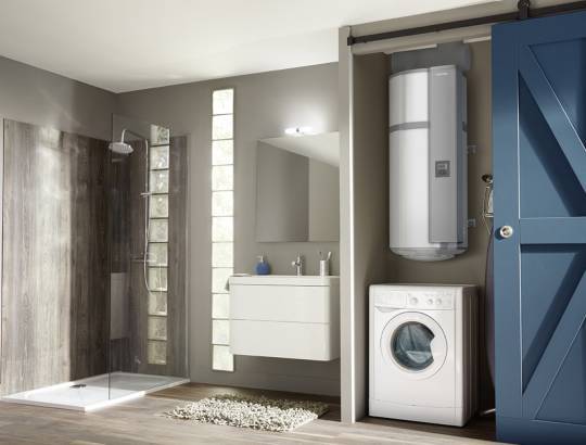 Vue d'ensemble d'une salle de bain avec un chauffe-eau thermodynamique installé au dessus d'un lave-linge